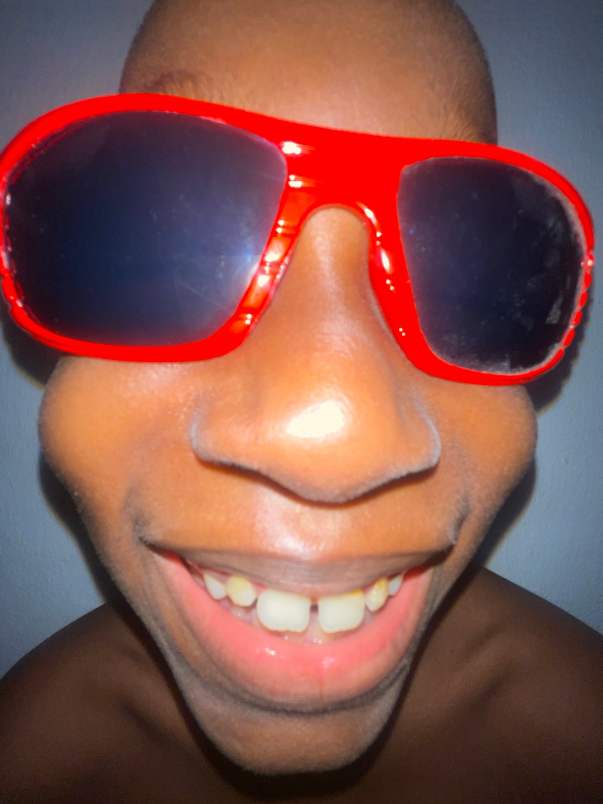 Close-up portrait series with bold sunglasses under red light, Ado