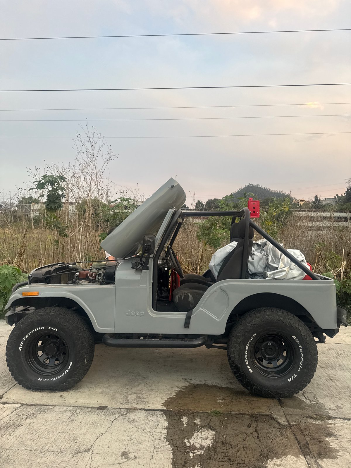 Grey Jeep undergoes hood-open maintenance in Mexico City