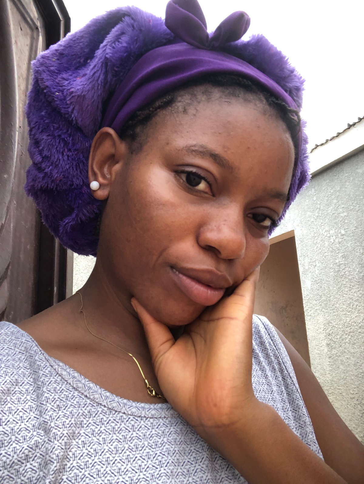 Woman in purple headwrap photographed indoors in Nigeria