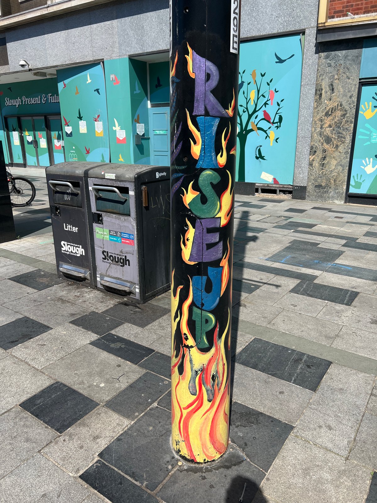 Spring street scenes documented in Slough include graffiti, blooming shrubs