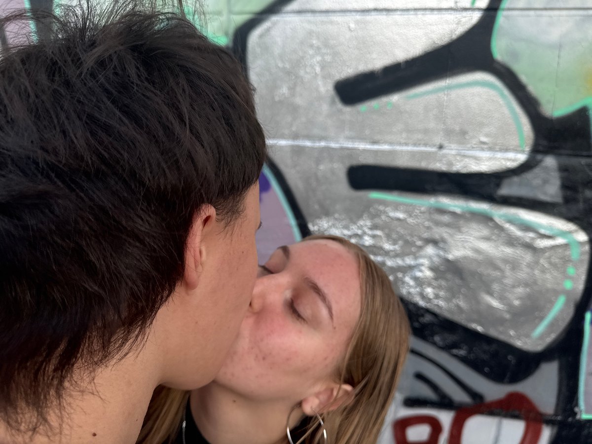 Young couple photographs playful moments near Perm street art