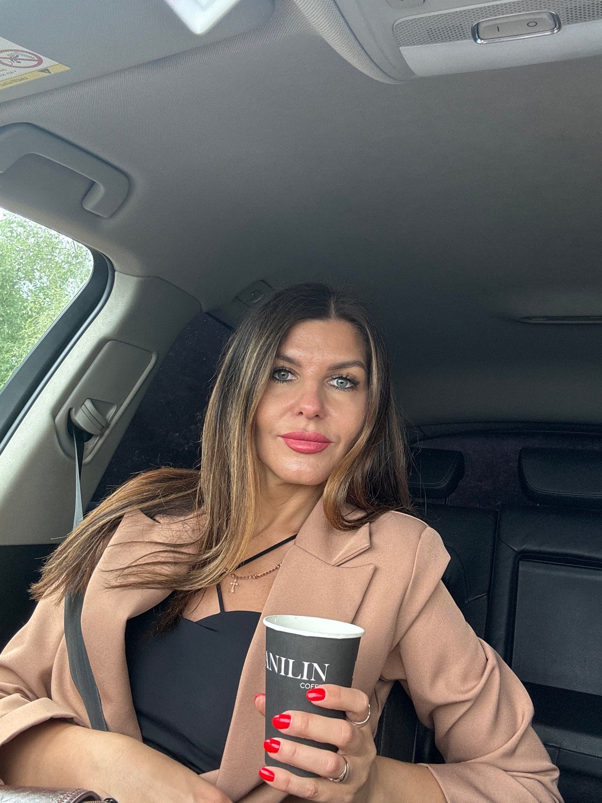 Woman takes selfies in car near water in Chaikovsky
