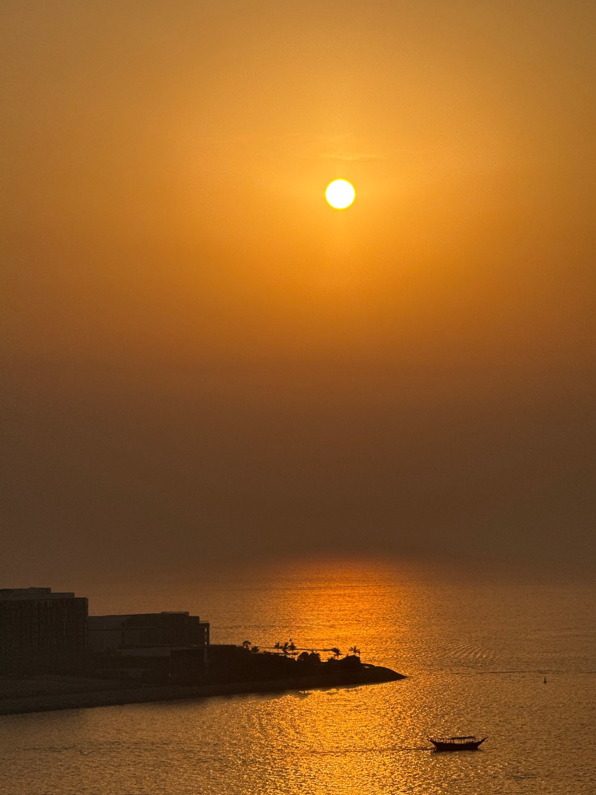 Golden sunset over the Arabian Gulf with Ain Dubai in view