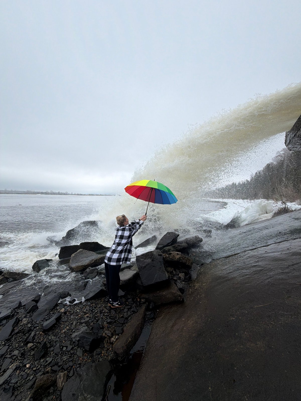 Rainbow umbrella moment captured at Russian waterfall