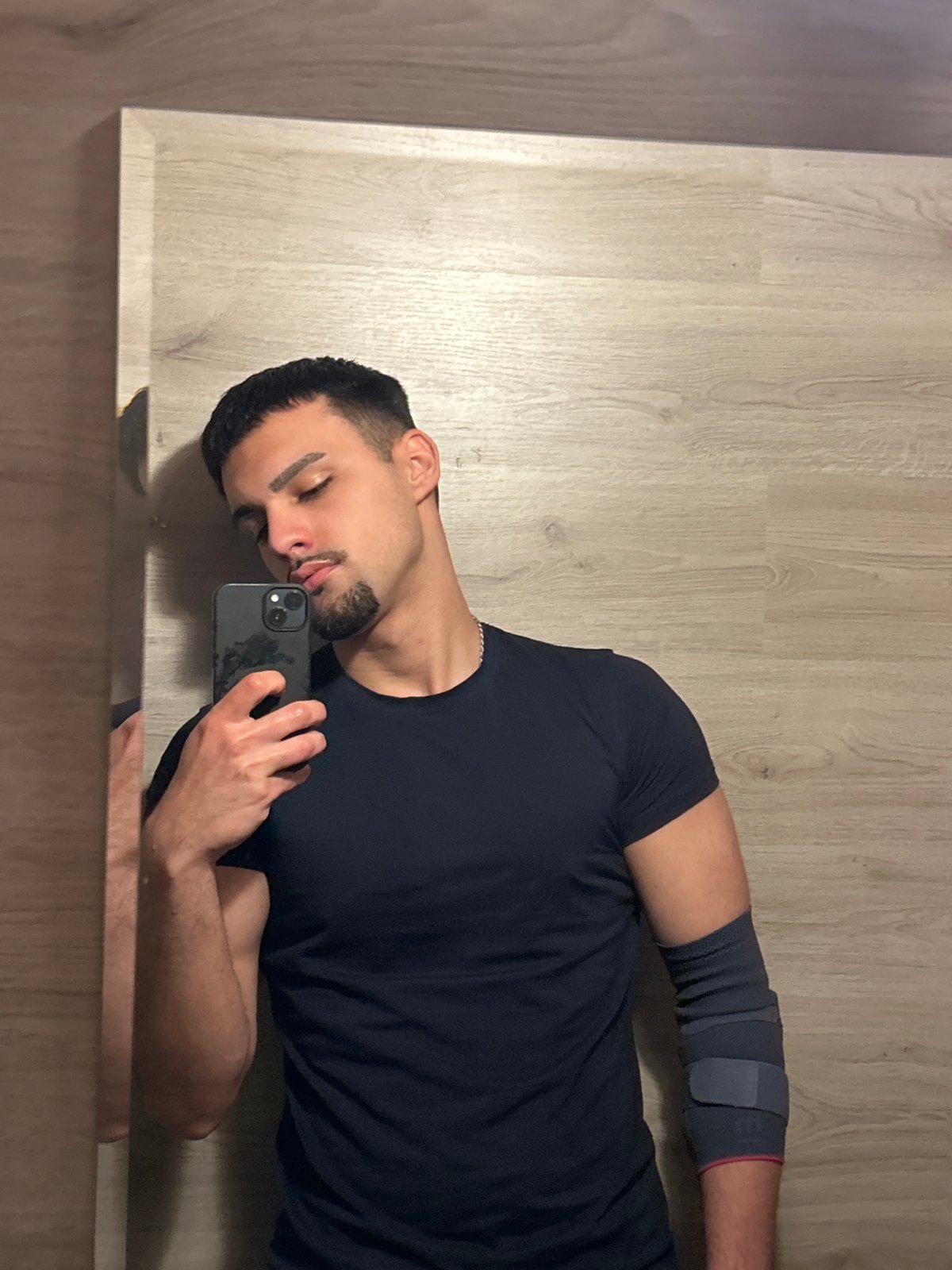 Man with elbow brace uses phone while resting in Sofia