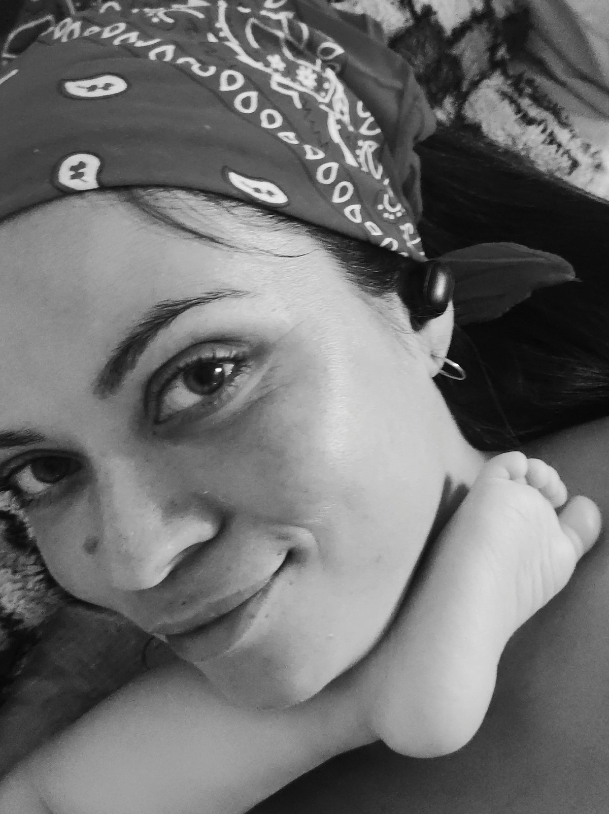 Woman in bandana relaxes with child during outdoor session
