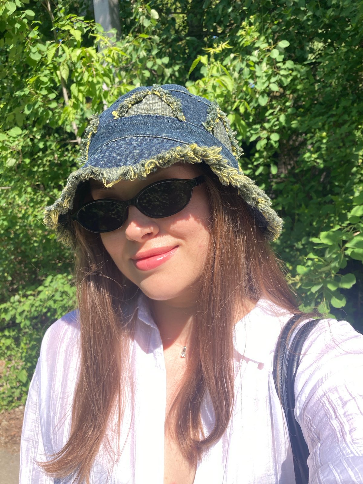 Woman photographed in outdoor poses under trees in Chaikovsky