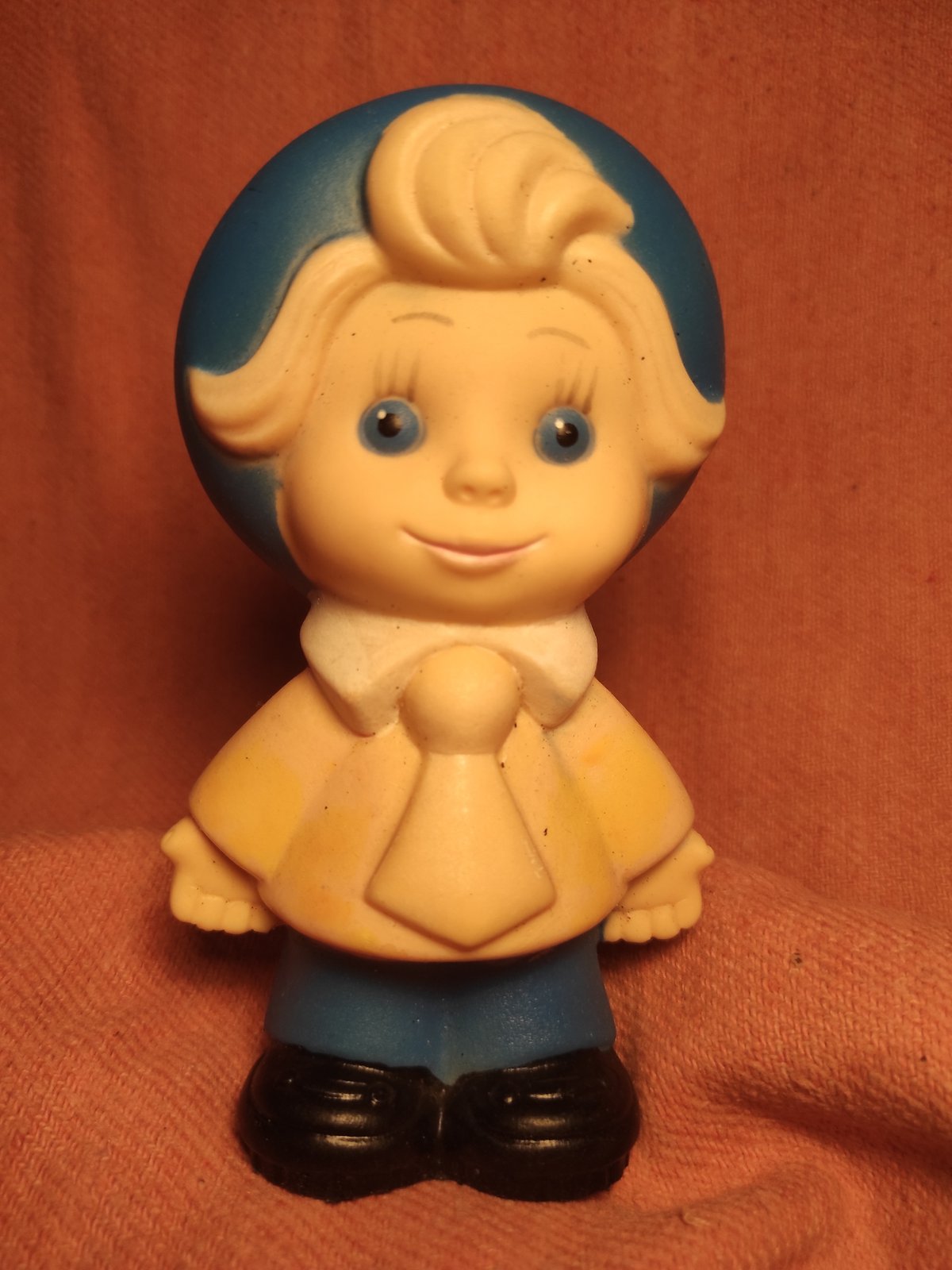 Vintage toy figures photographed against fabric backgrounds in Chernihiv