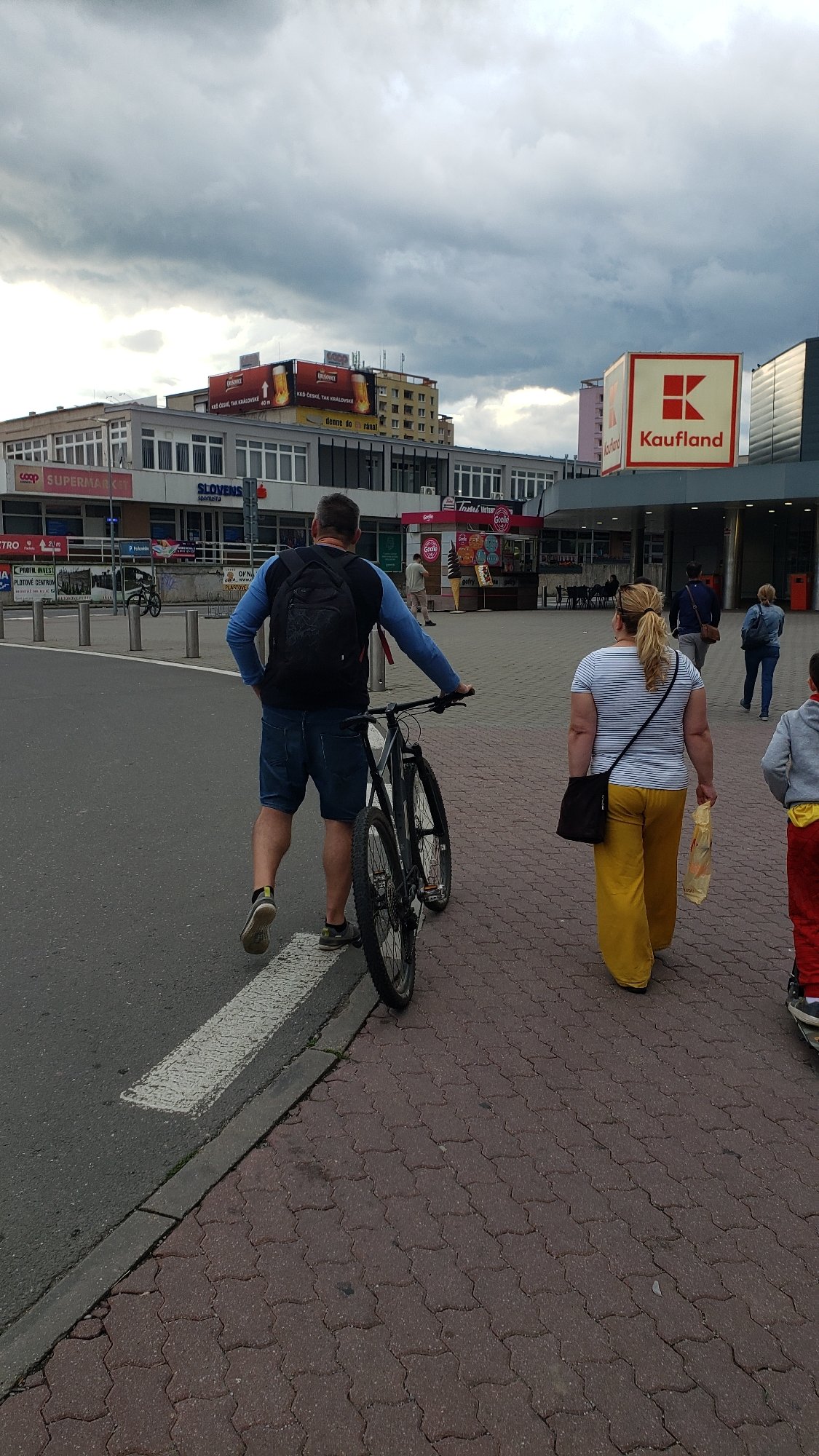 Everyday movement along Prešov's riverside paths on a cloudy July evening
