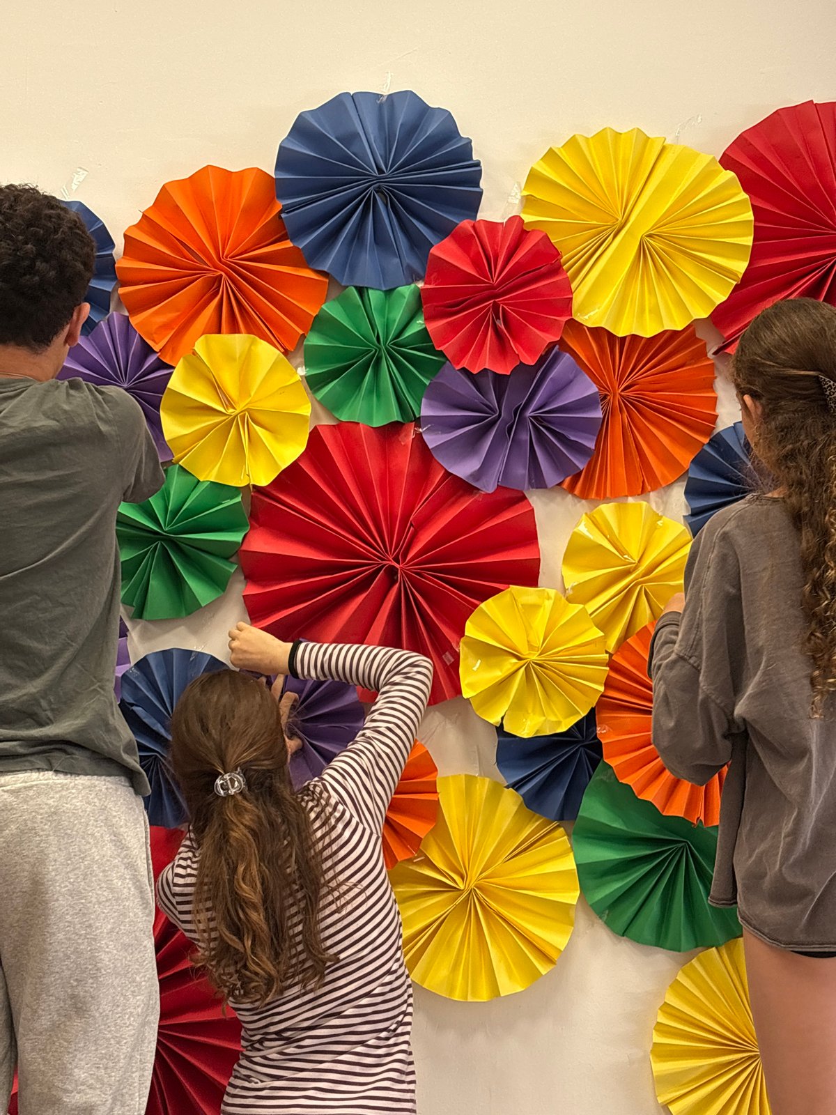 Youth decorate indoor space with colorful fans in Tel Aviv