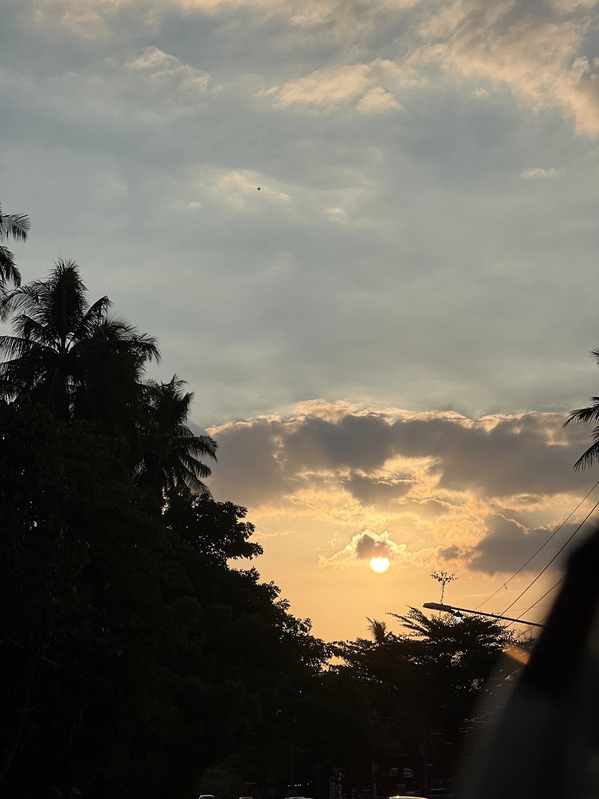 Golden hour hits Kubutambahan, palms and road traffic at dusk