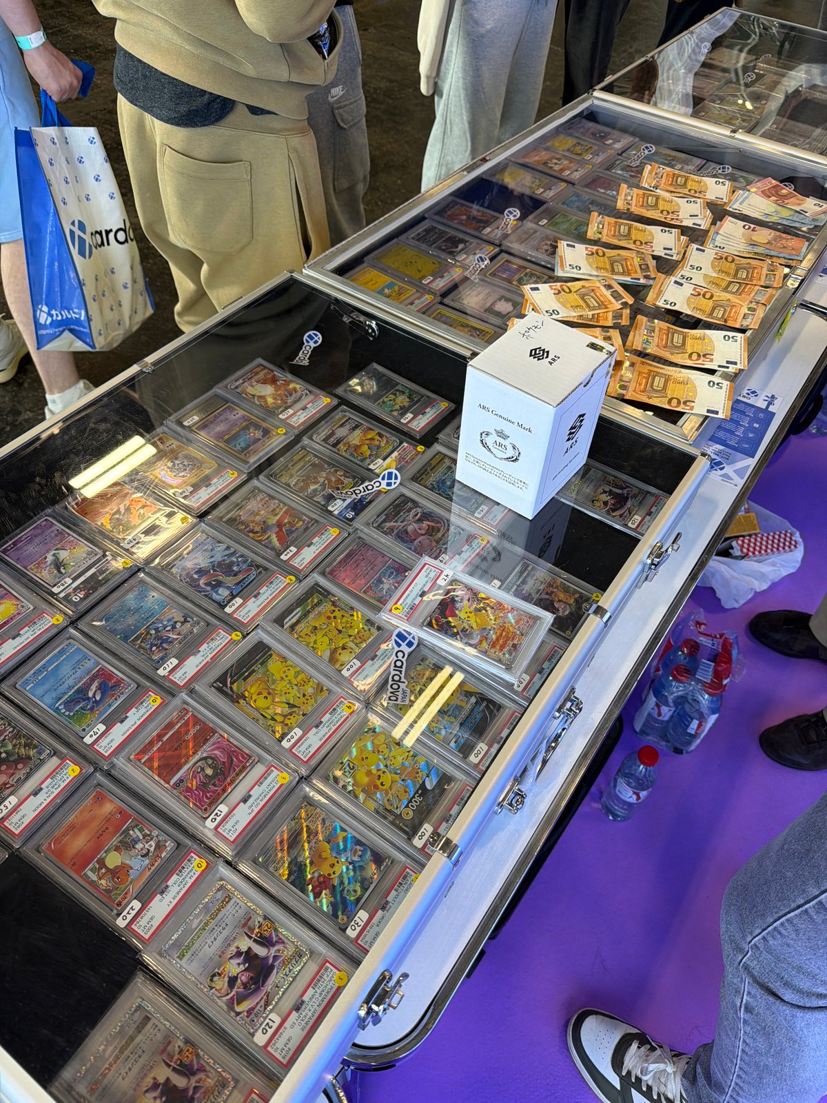 Graded Pokemon cards displayed with Euro cash in Paris