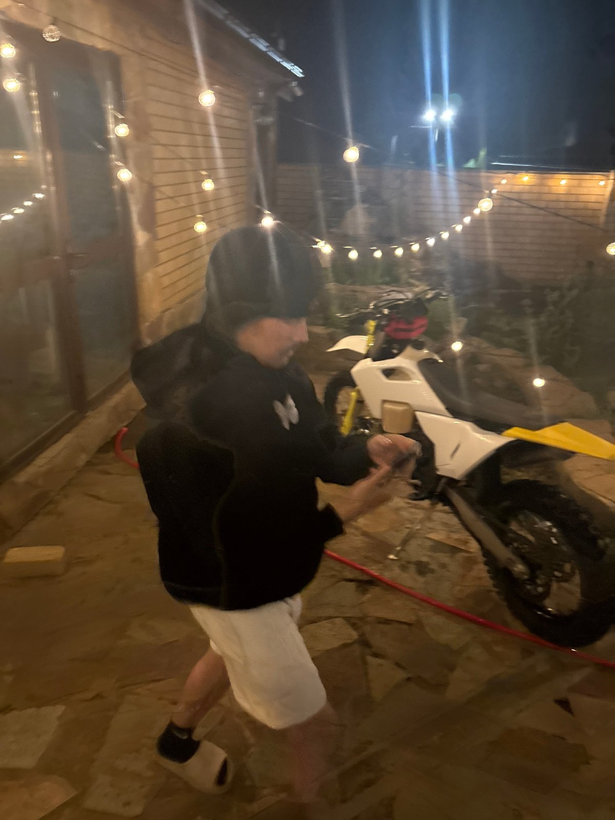Man poses with dirt bike during nighttime gathering in Russia