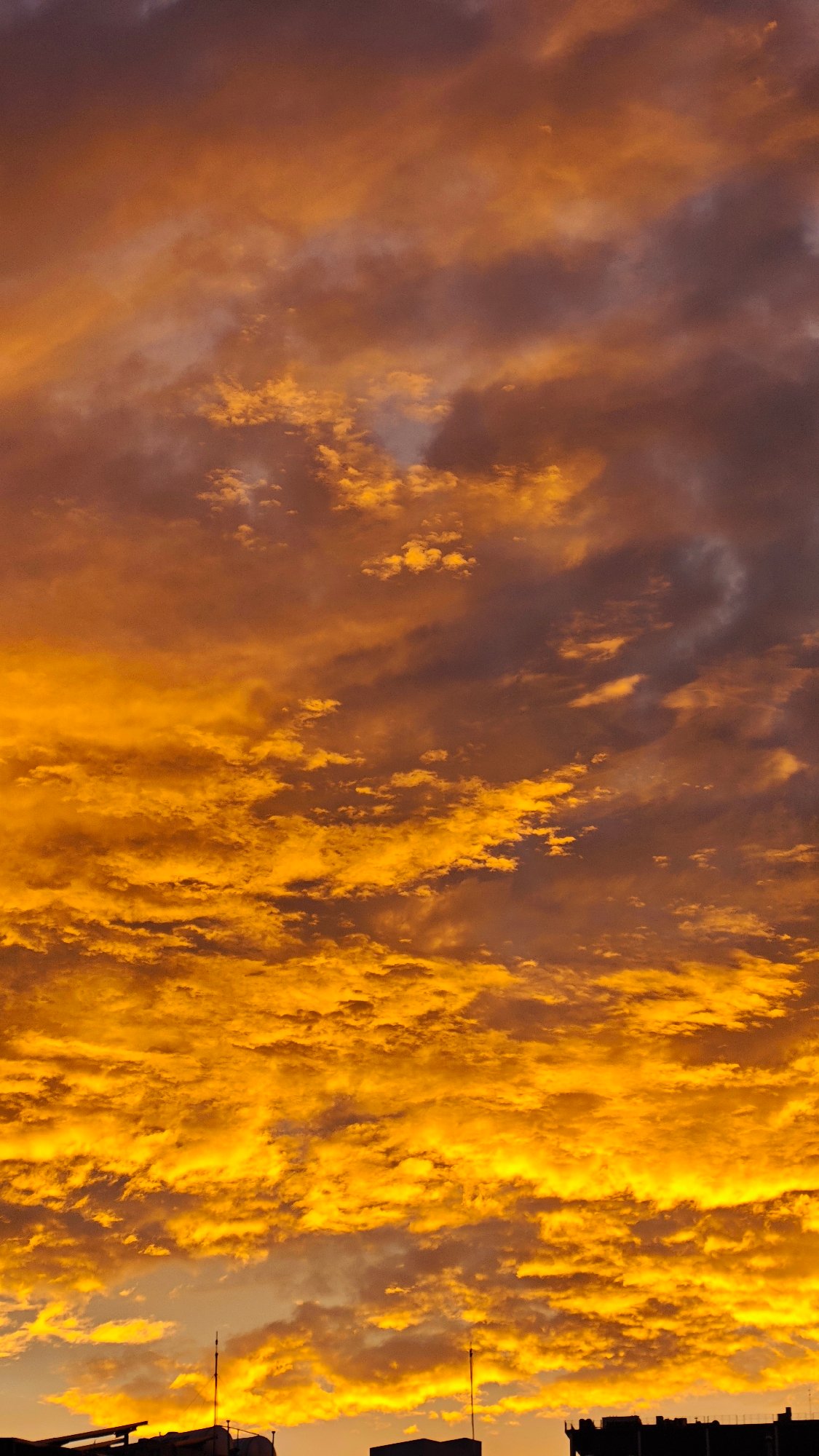 Hanoi street life glows under a fiery evening sky