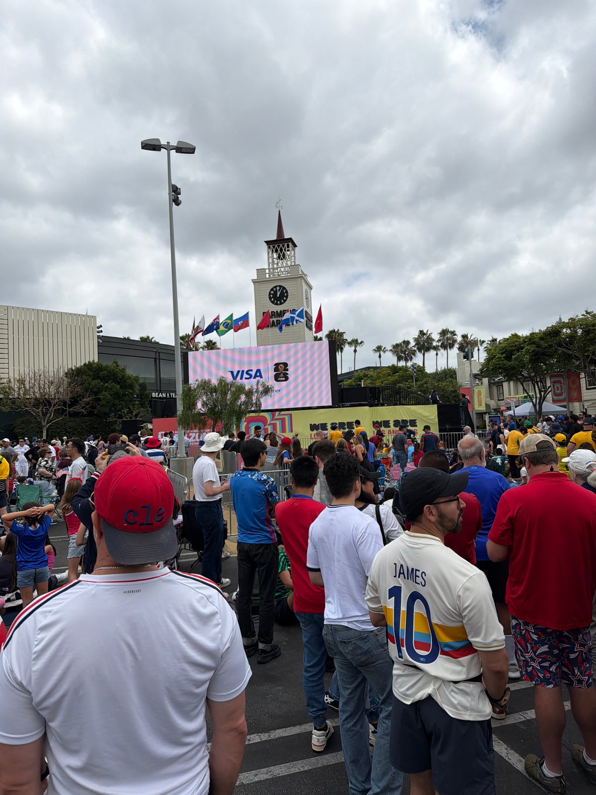 Crowd gathers around a large outdoor screen in LA