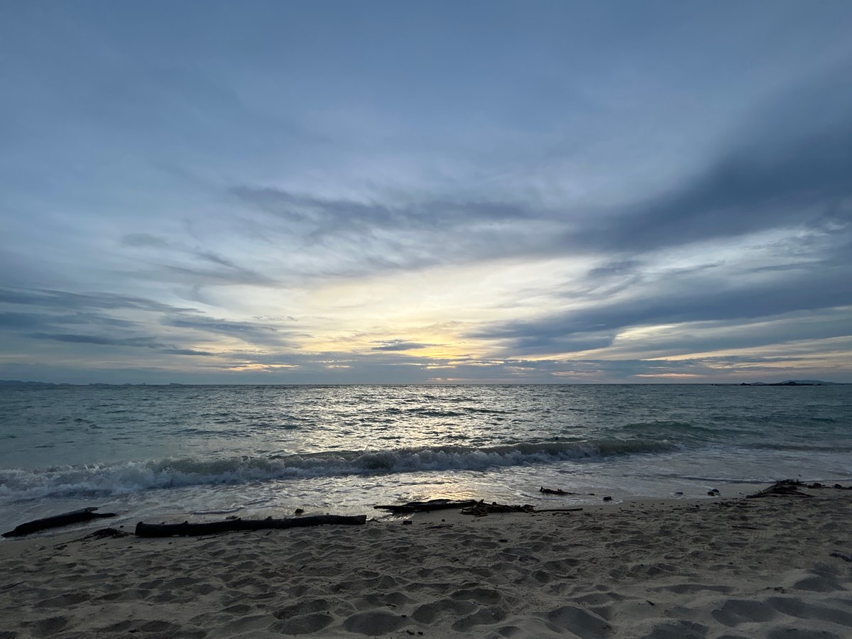Koh Phangan beach at dusk, clouds stacked above a fading horizon