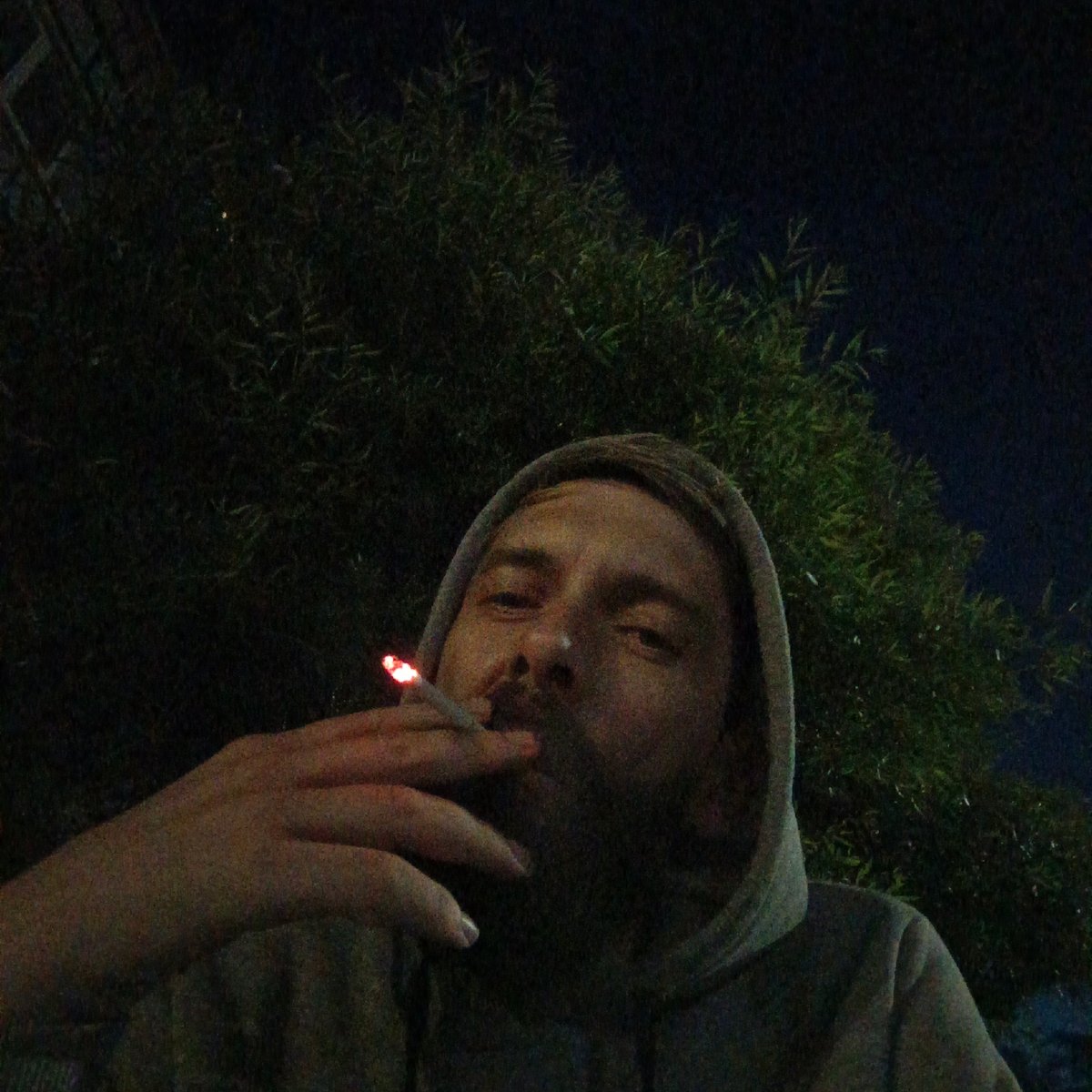 Late night smoking break on illuminated street in Markovskiy