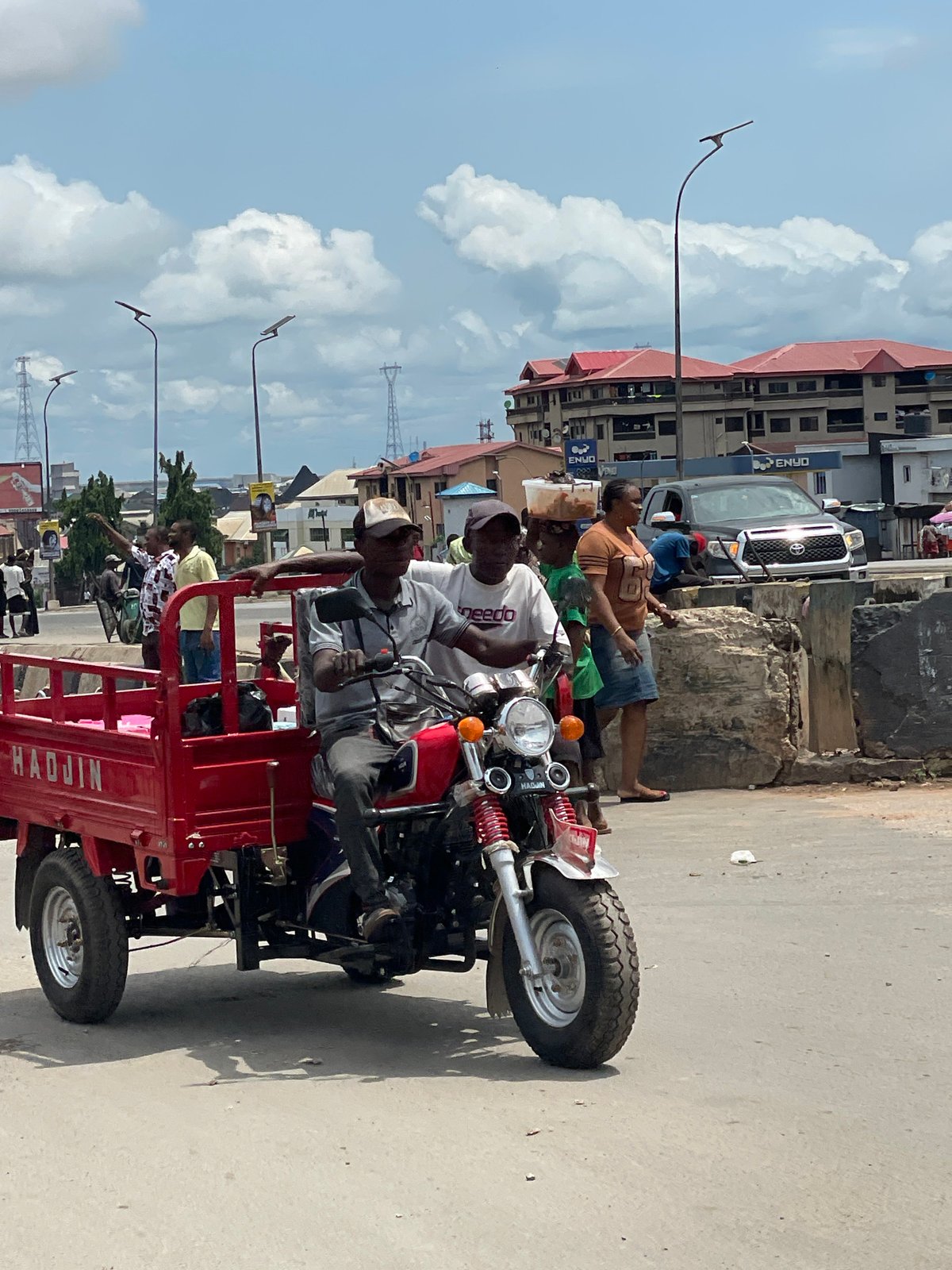 Street life and market trade in Onitsha, road damage visible