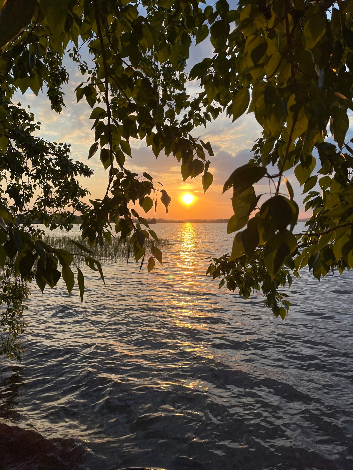 Two people watch sunset over water near Yekaterinburg