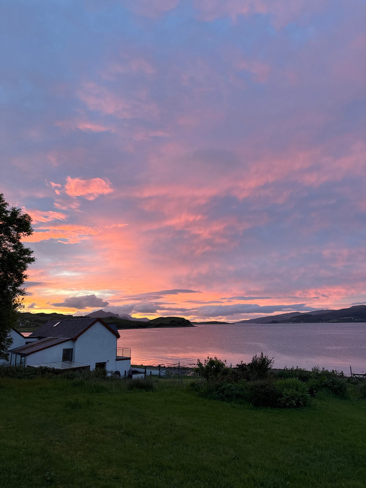 Vibrant sunset documented over Sconser coastline, white house featured
