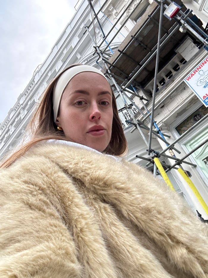 Person in fur coat photographed walking London residential street