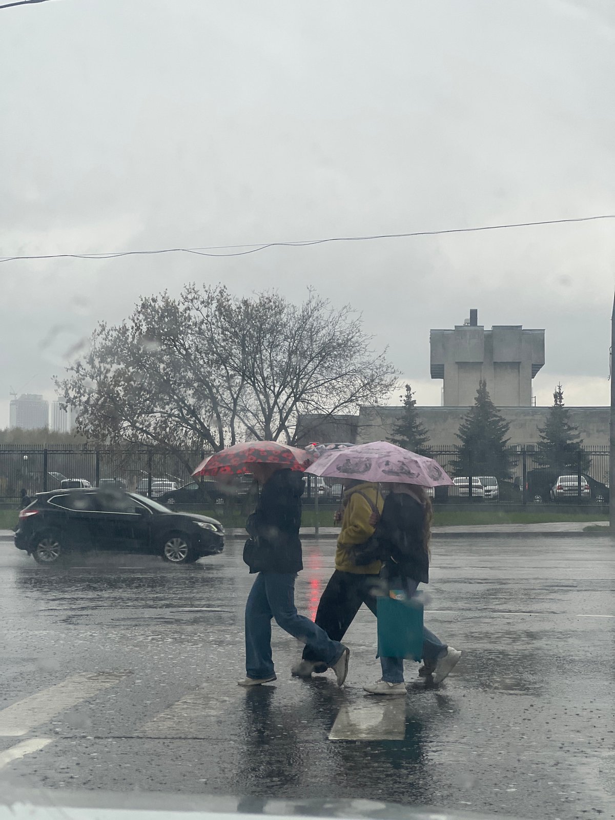 Two pedestrians cross Moscow street during morning rain
