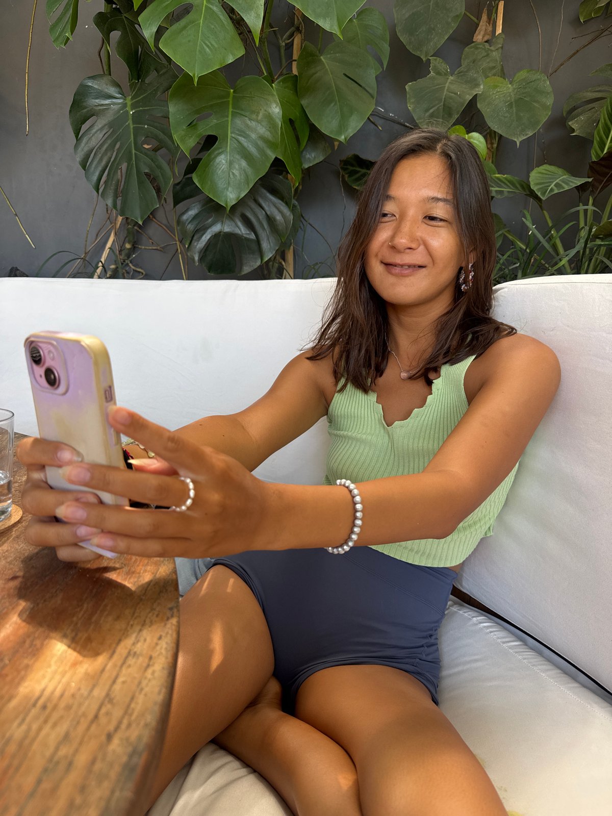 Woman takes morning selfie on outdoor couch in Kuta Selatan