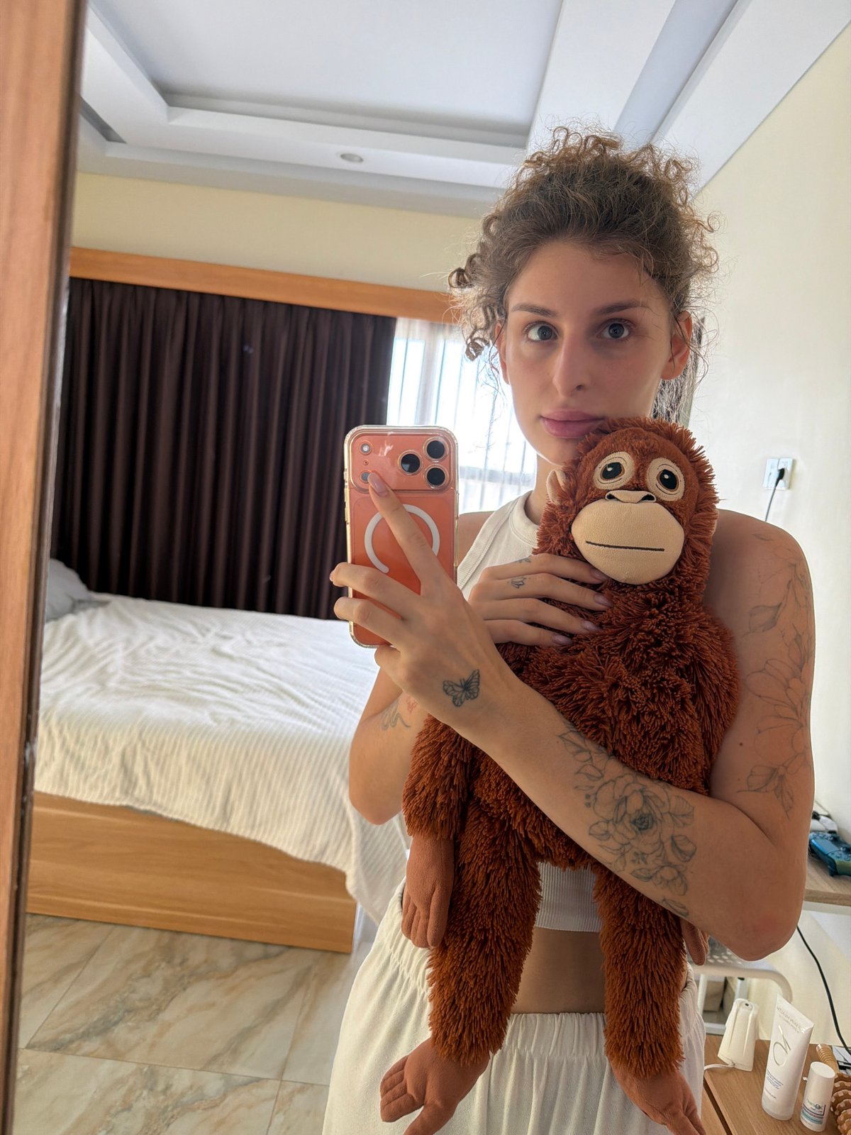 Hotel room outfit shots in Bali with a stuffed orangutan
