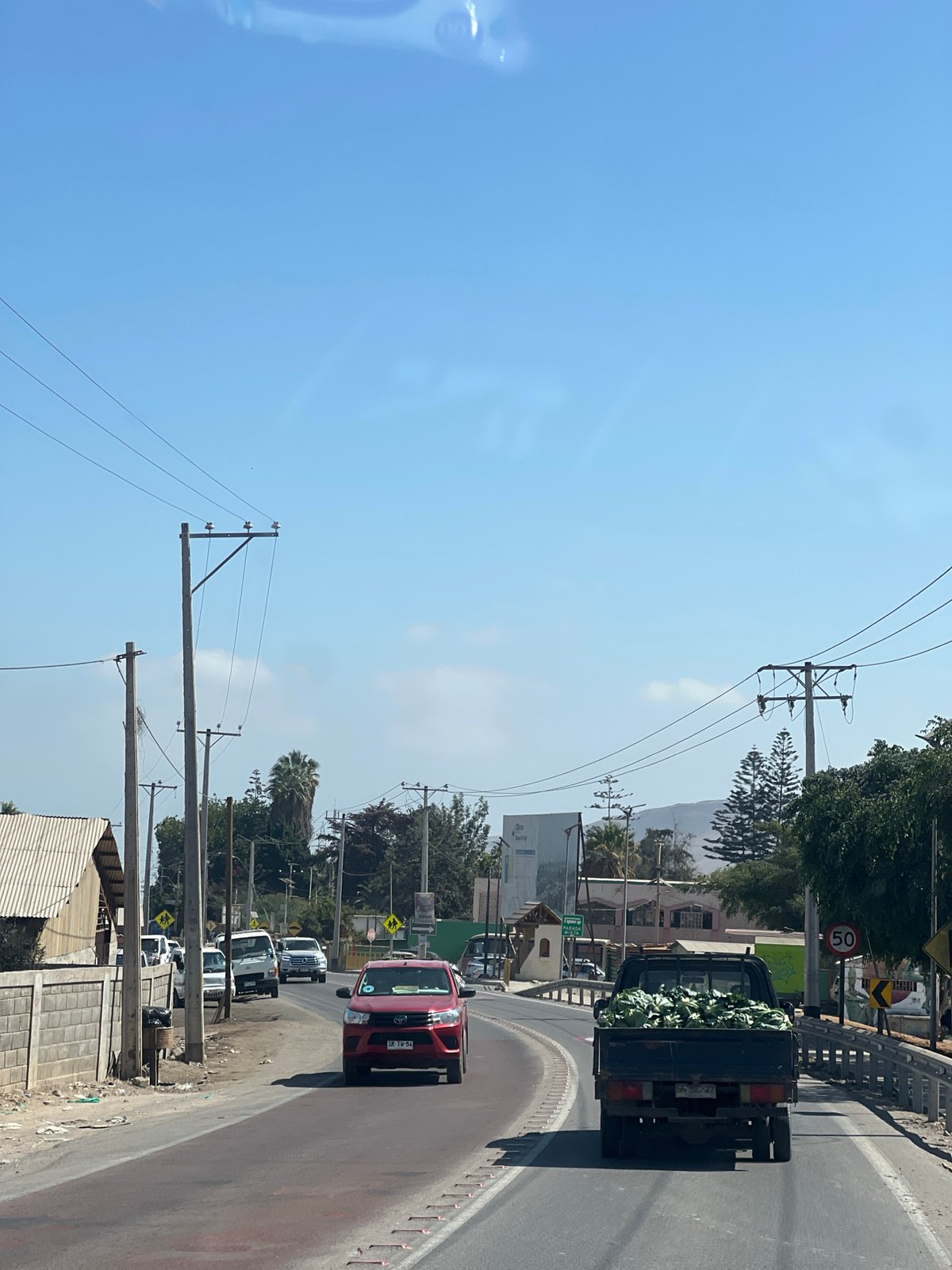 Vehicles spotted on sunny Arica street, truck carrying vegetables