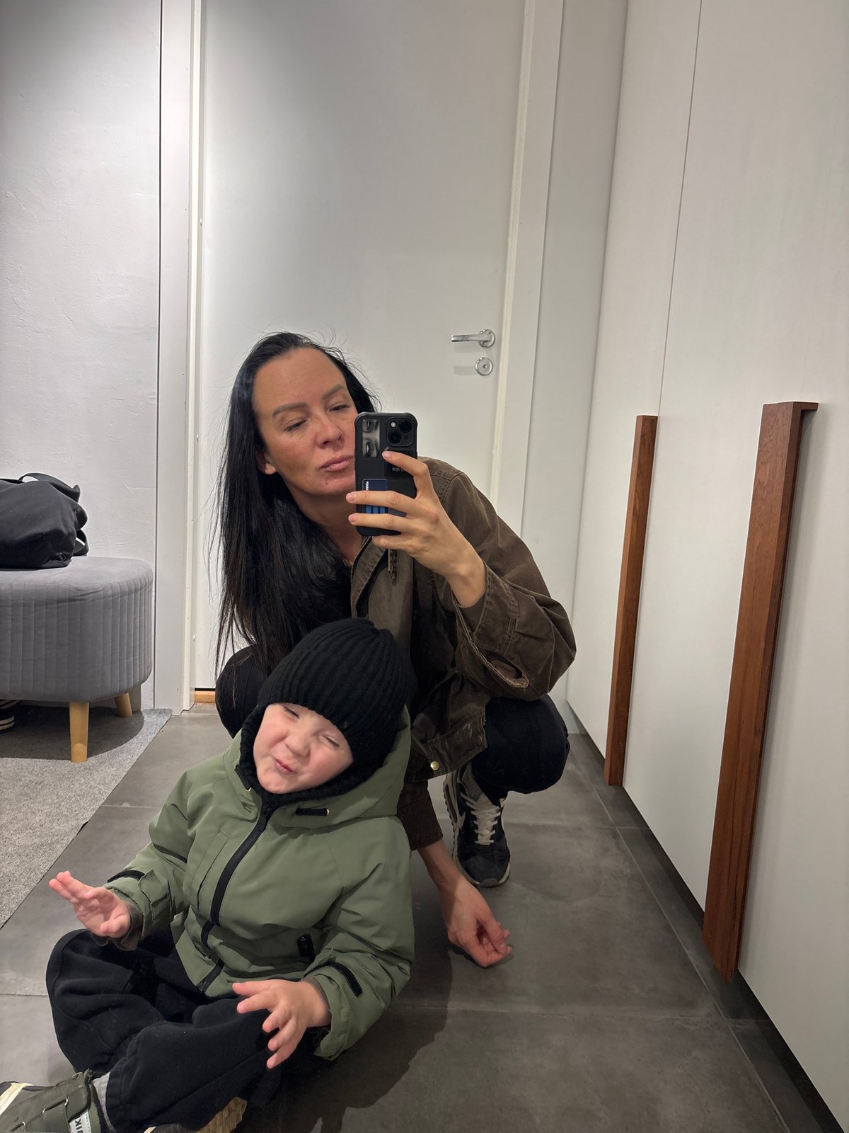 Woman takes mirror selfie with child in Chaikovsky