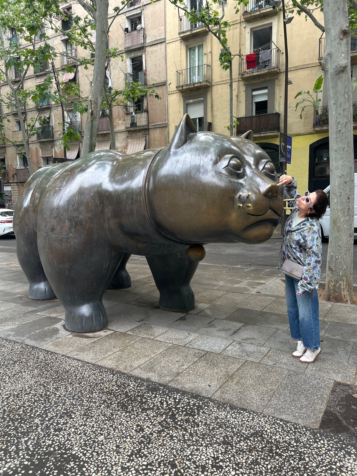 Tourist interacts with Botero cat sculpture in Barcelona