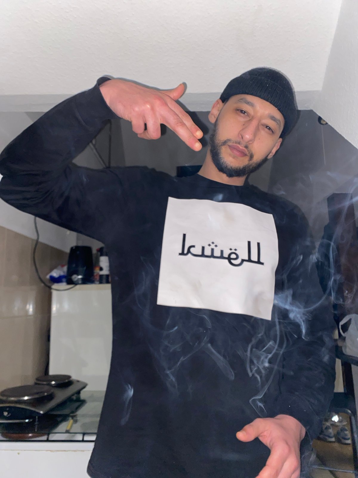 Man poses with hand gestures in Bischheim kitchen