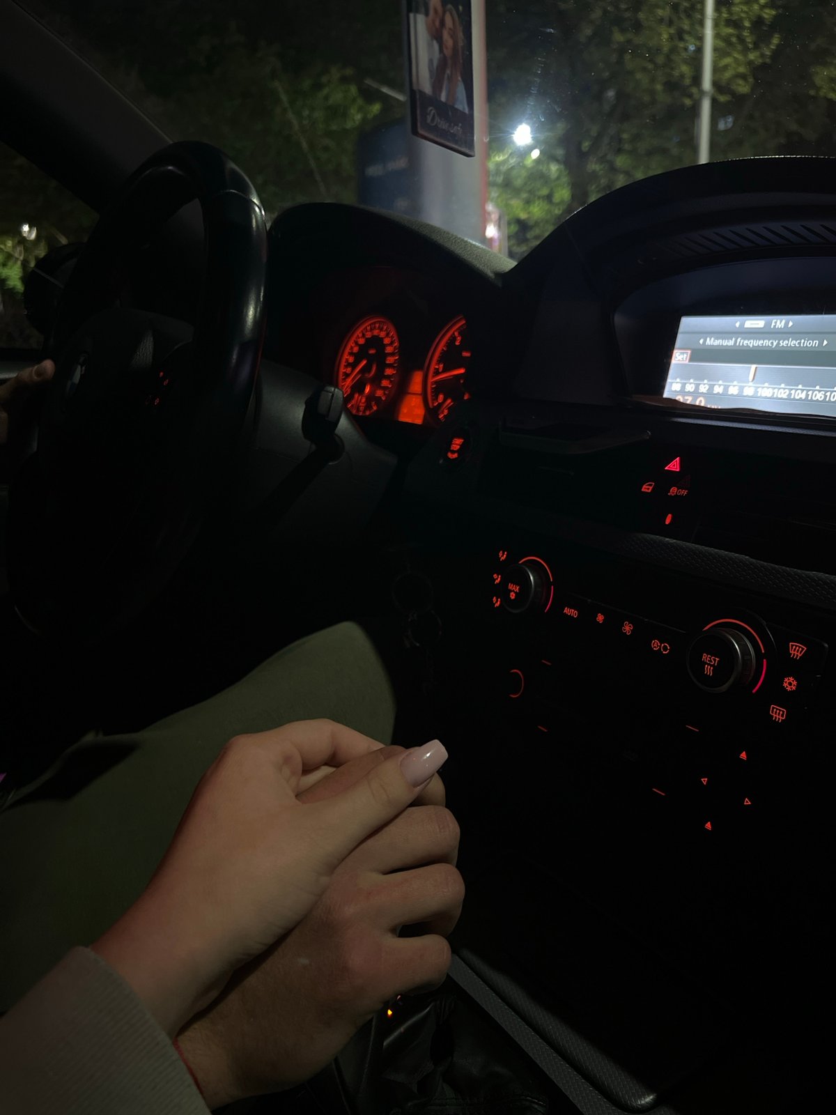 Couple holds hands inside BMW at night in Plovdiv