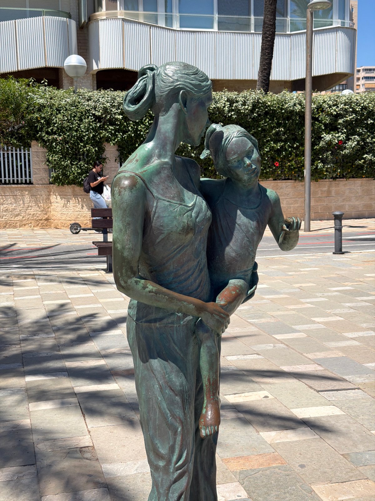 Woman walks beachfront promenade in sunny Alicante