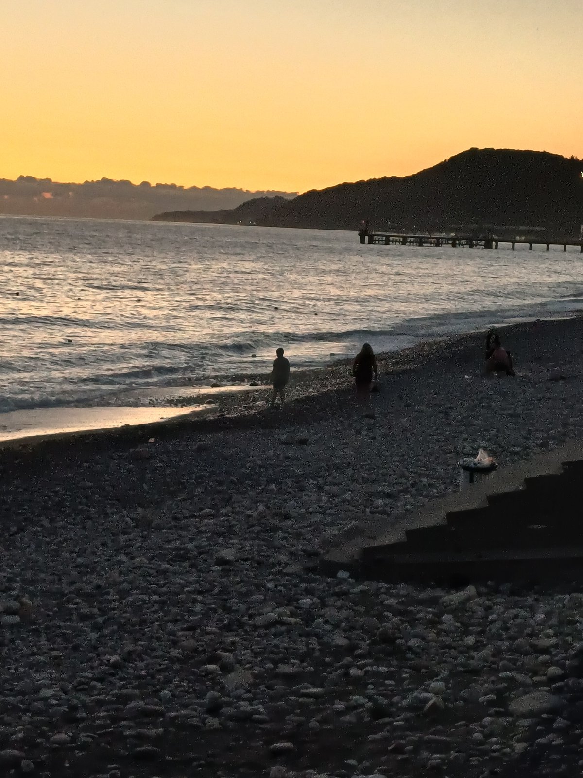 Family evening on the Sochi pebble beach at sunset