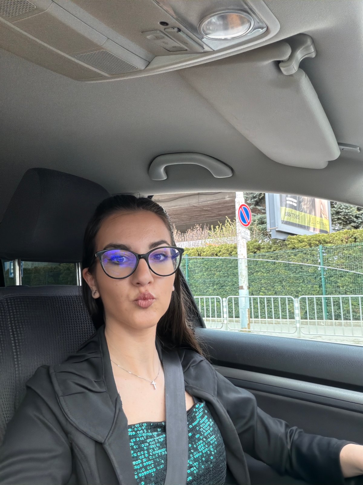 Woman makes peace sign while sitting in car, Sofia