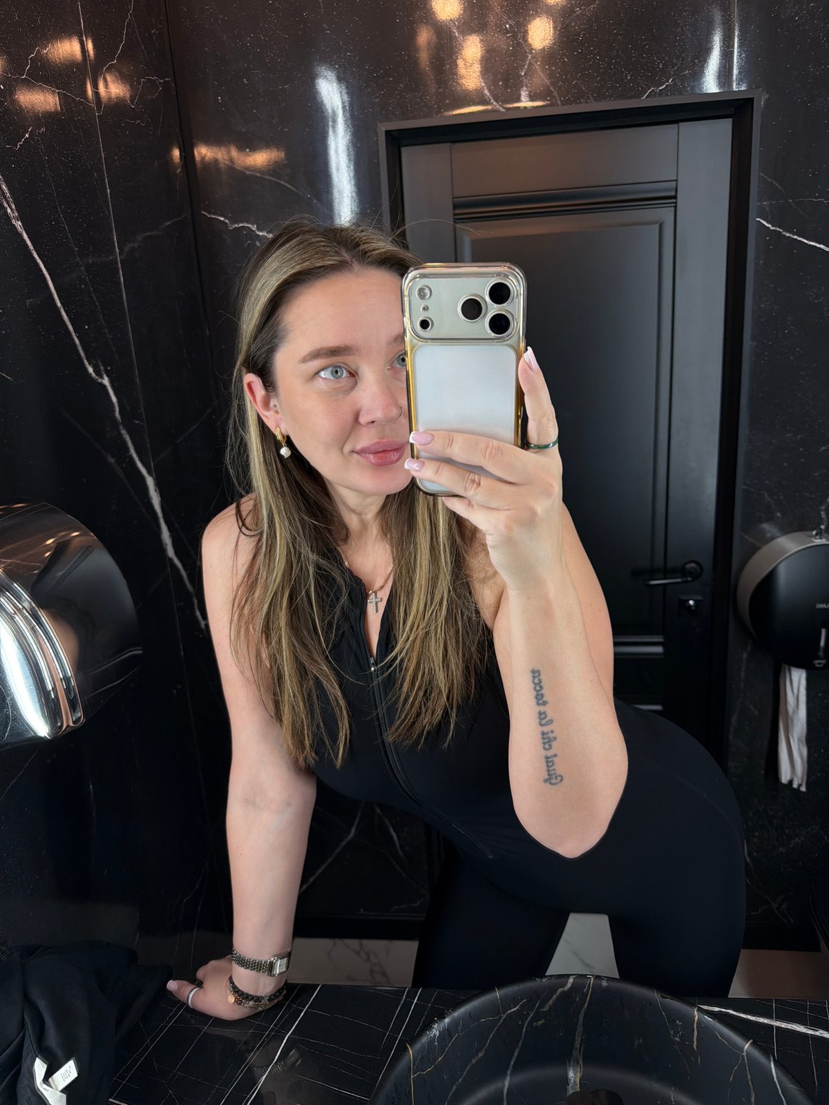 Woman takes bathroom selfies in black marble Moscow restroom