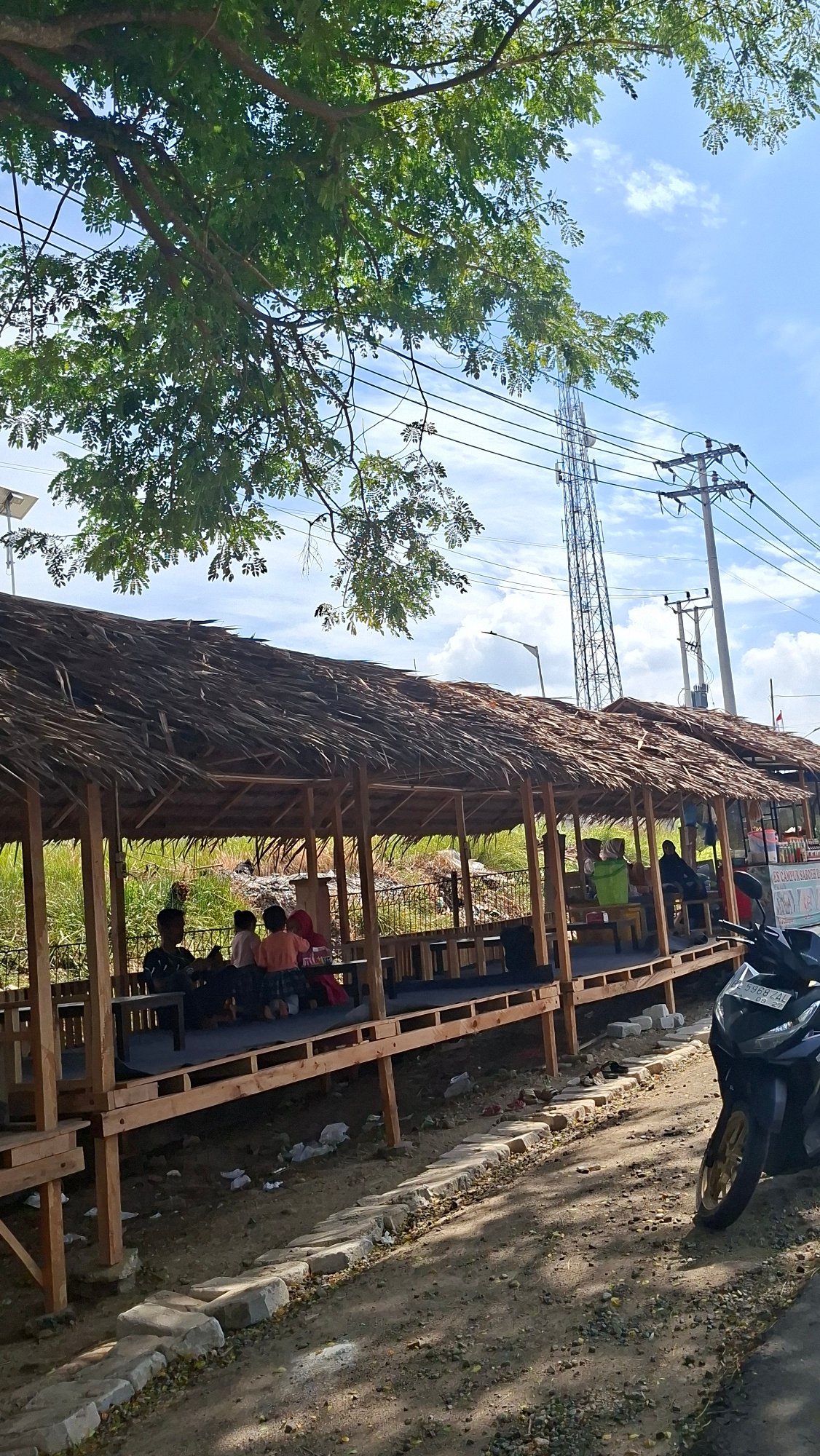 Roadside life and logistics along a Lhokseumawe commercial strip