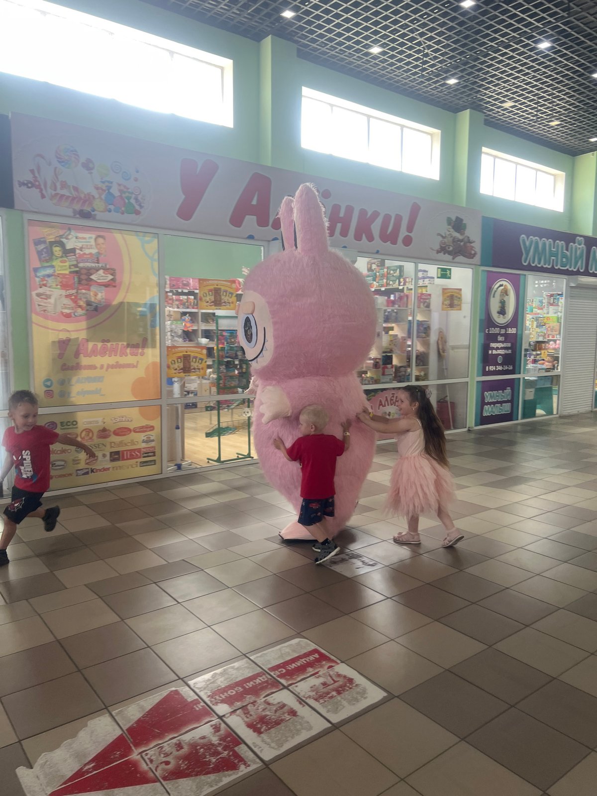 Pink bunny mascot meets the mall crowd at a beauty store