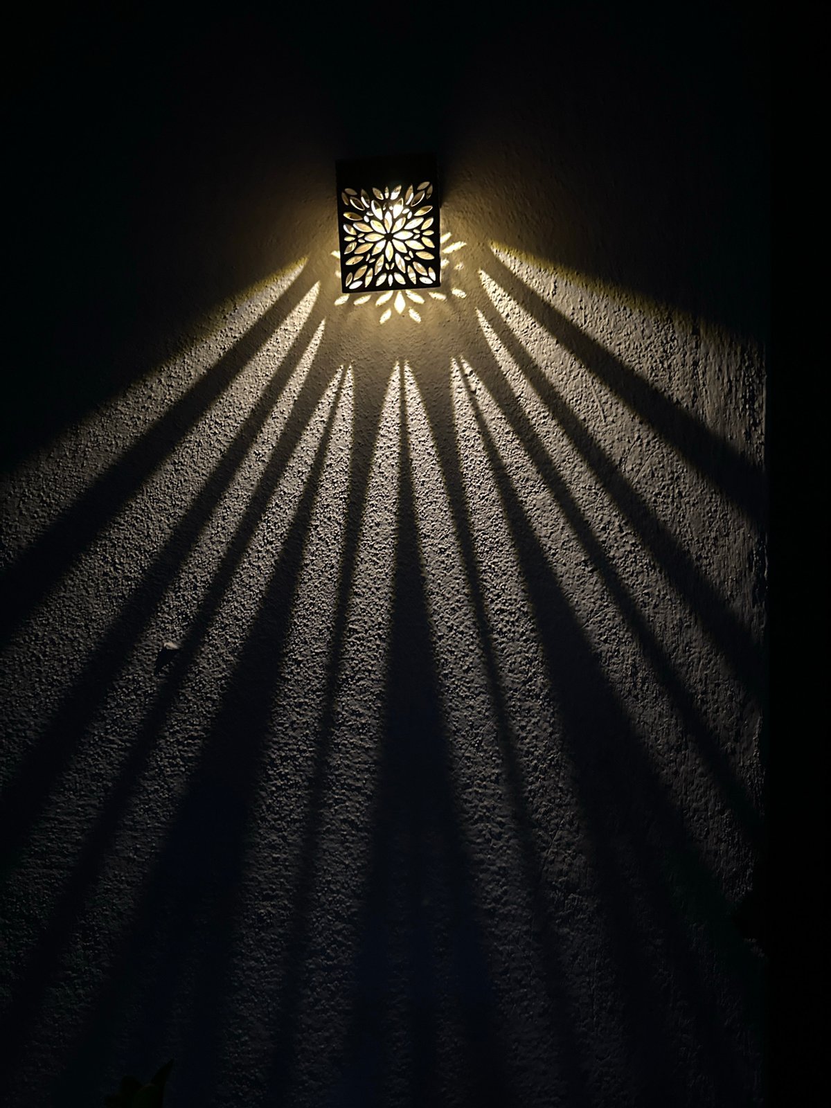 Ornate lantern casts starburst shadows at Villa Pasquali