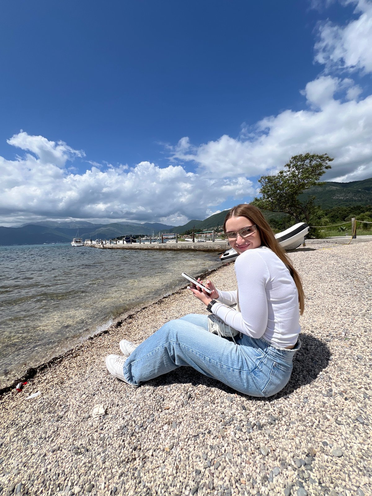 Woman relaxes on pebble beach in Tivat, Montenegro