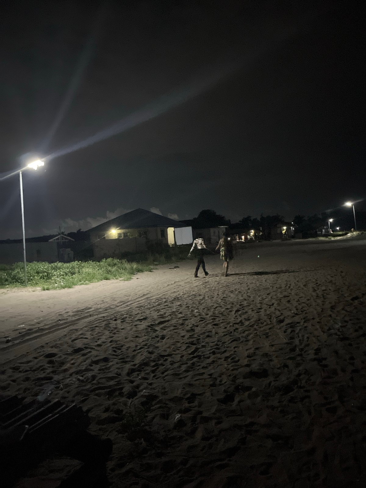 Two people spotted on urban beach during cloudy evening