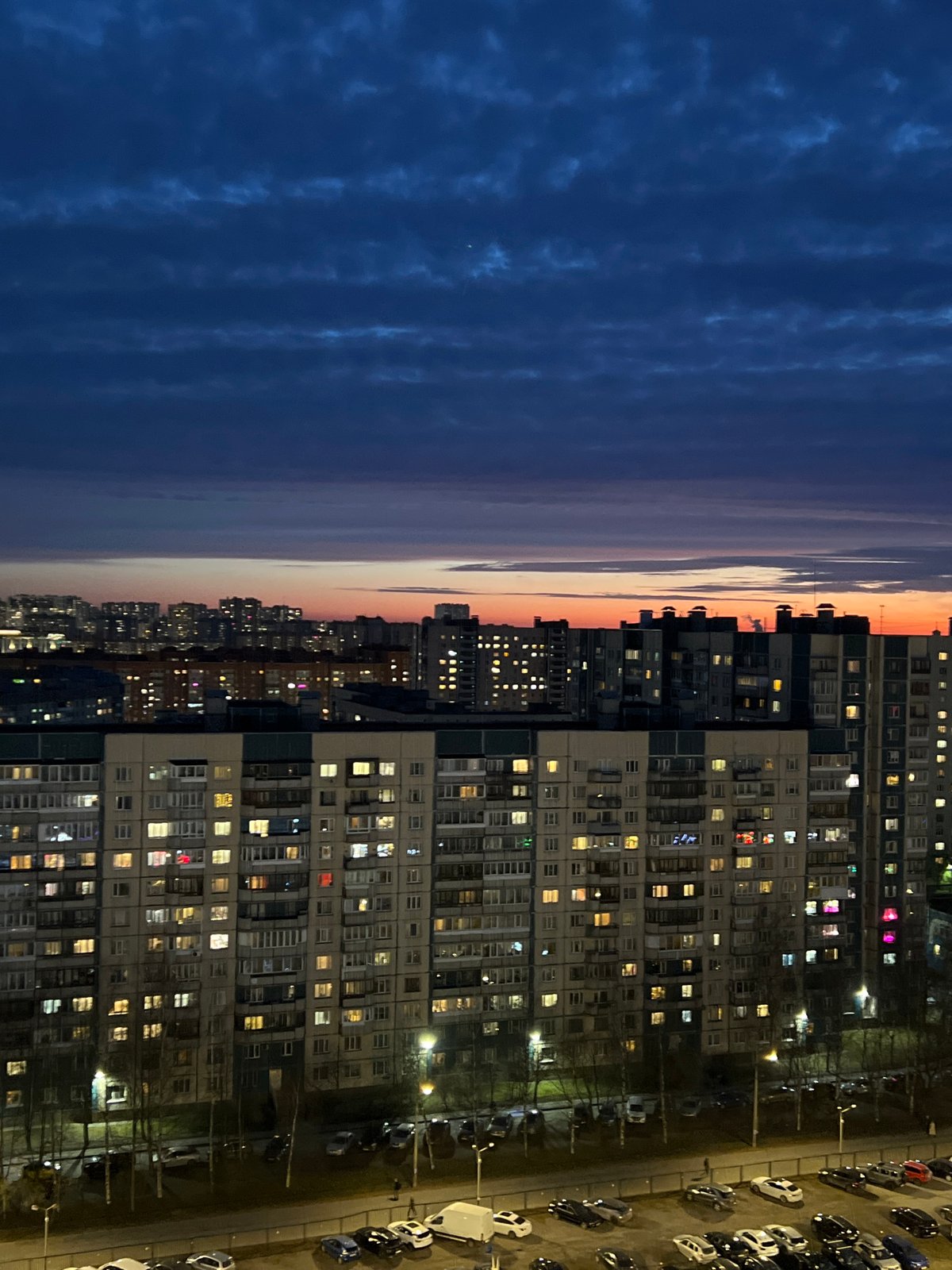 Evening lights illuminate Saint Petersburg apartment buildings at dusk