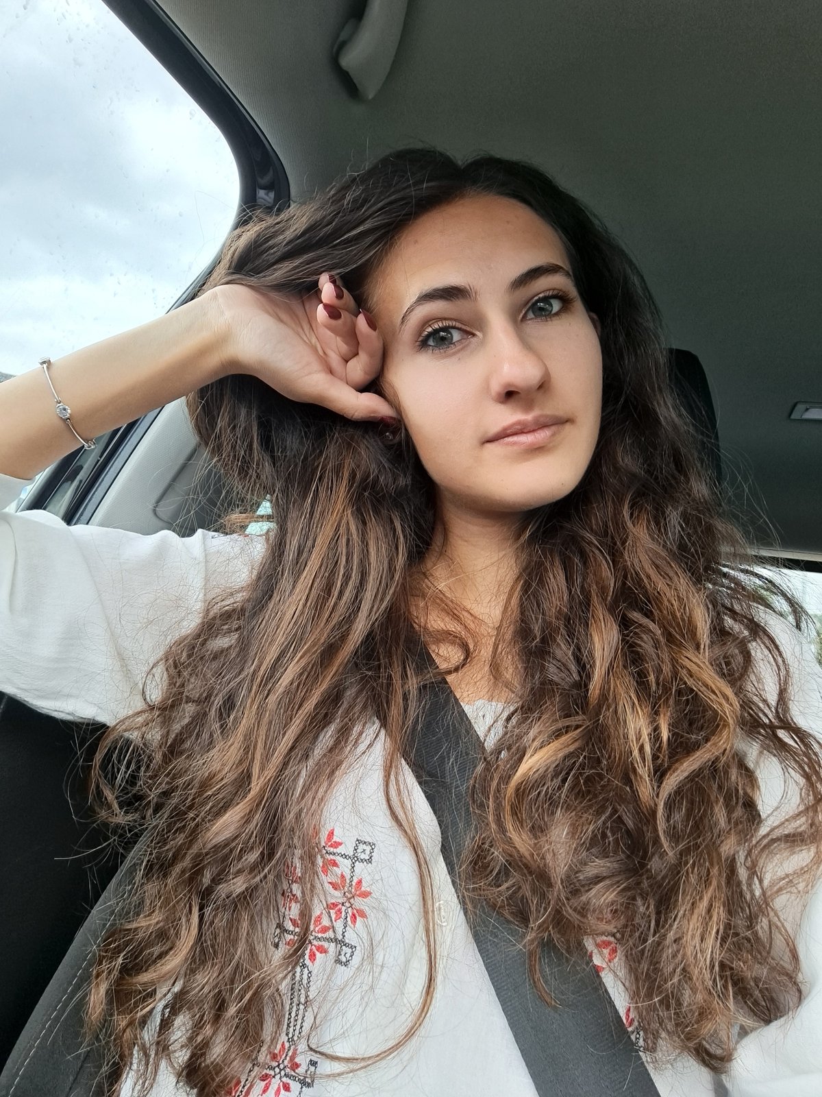 Woman in embroidered blouse observed in car, Sofia