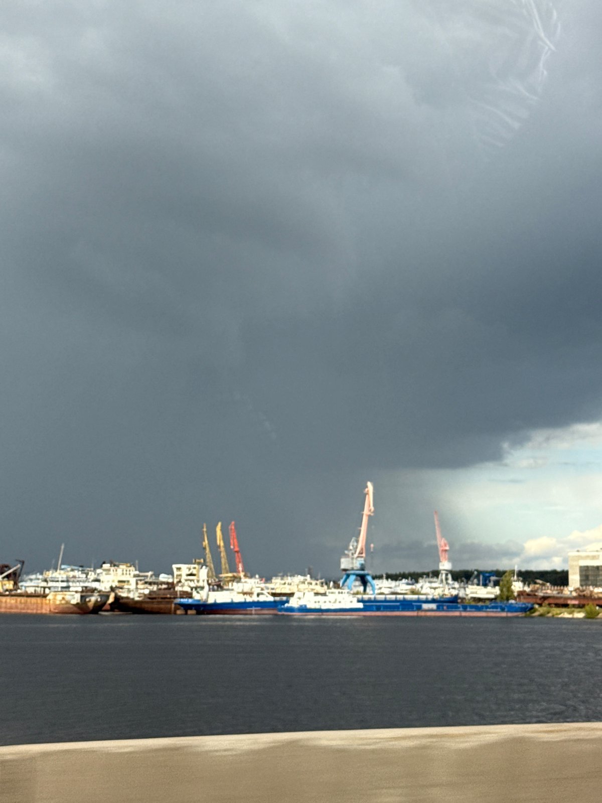Ships and cranes spotted at Chaikovsky harbor under cloudy skies
