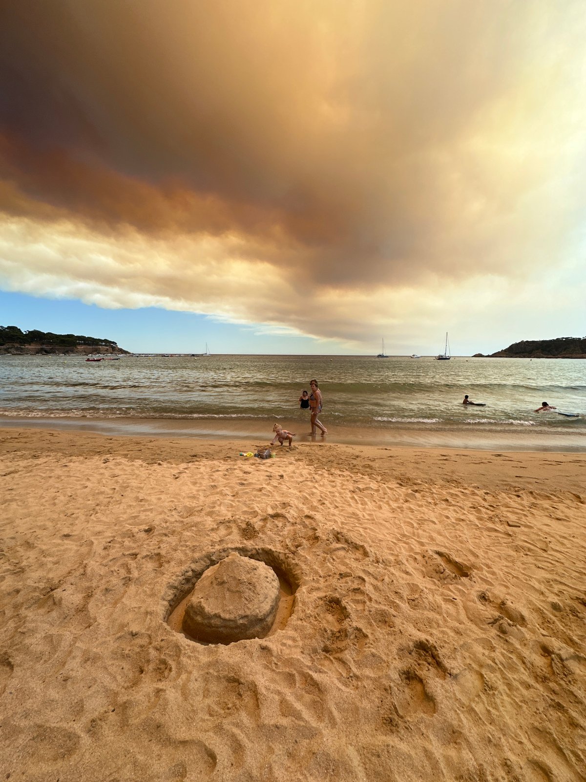 Wildfire smoke looms over Sant Feliu de Guíxols beach