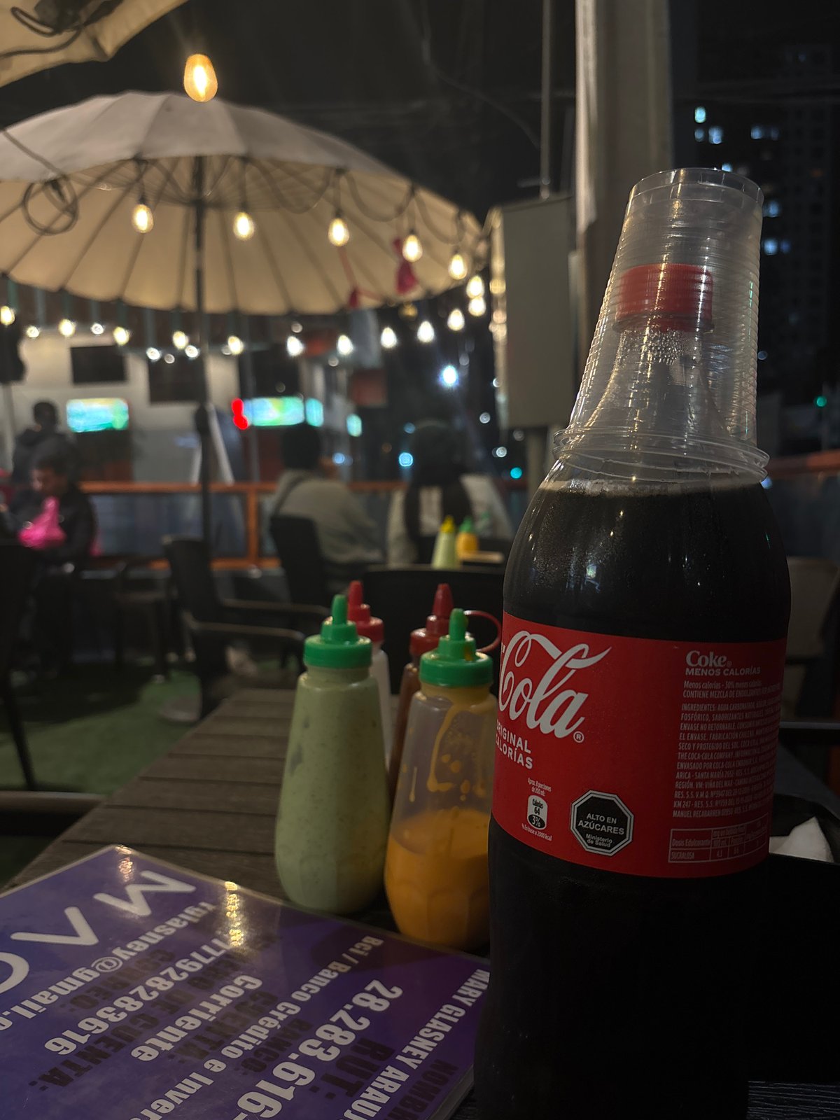 Late-night street dining under string lights near Mr. Dogs, Iquique