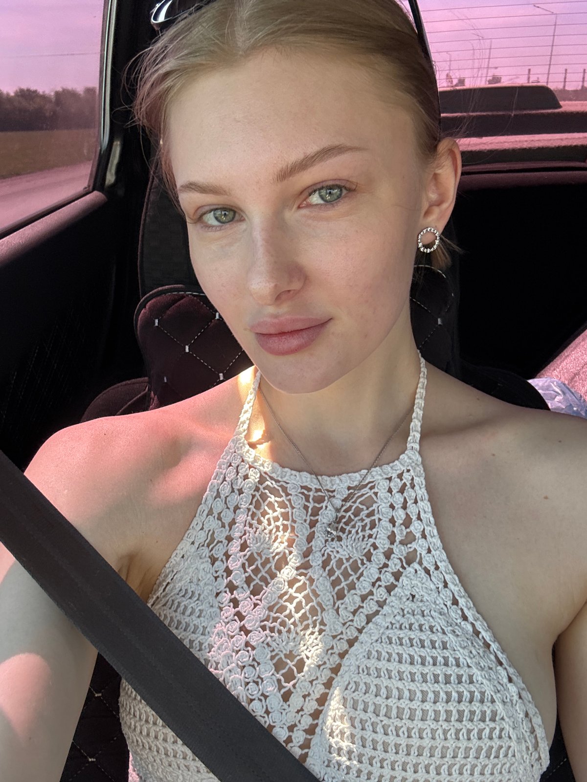 Woman in white crochet top photographed in car, Perm