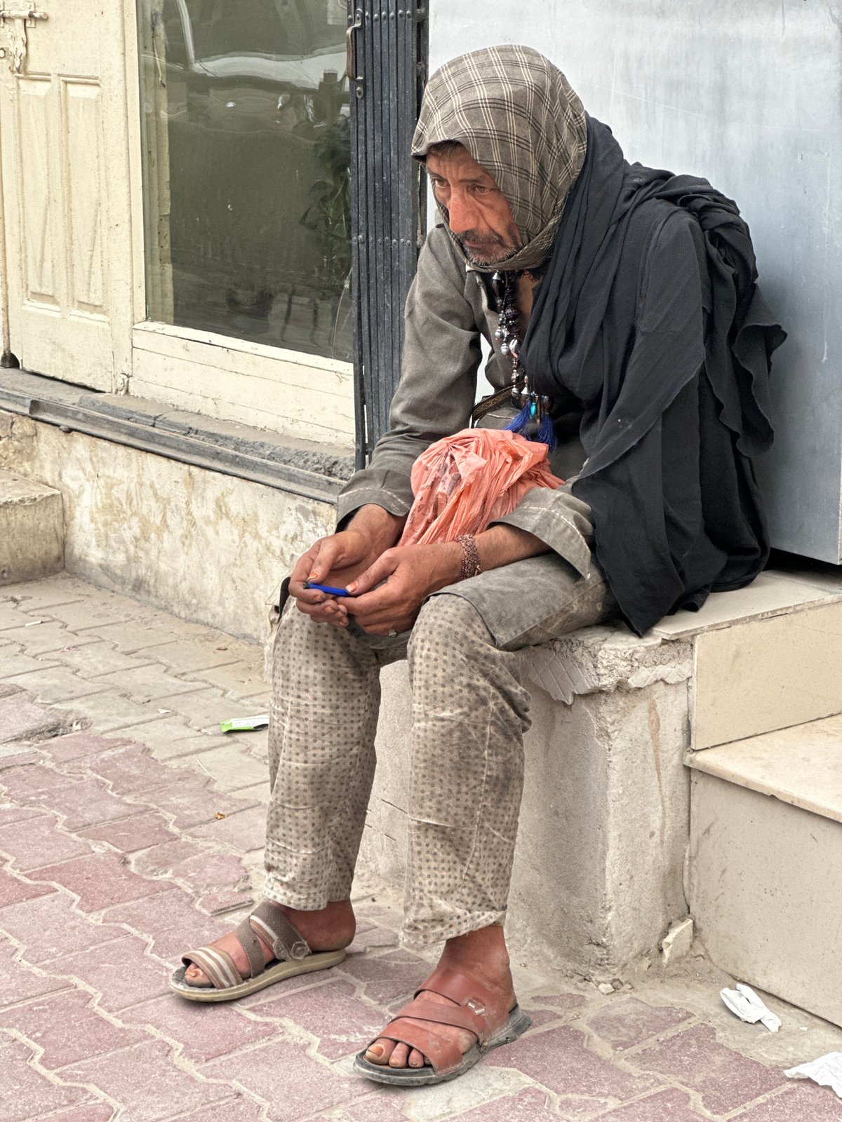 Elderly man rests outside building in Quetta, Pakistan