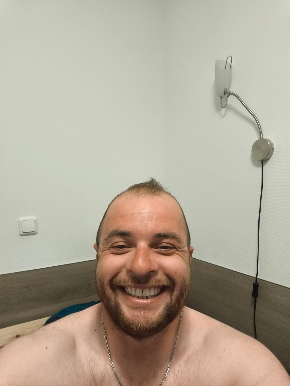 Man observed in bedroom with mounted wall lamp